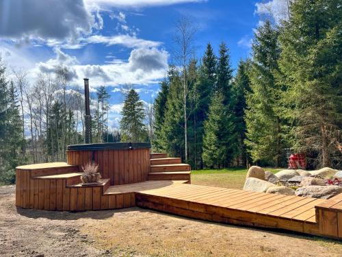 a wooden deck with a hot tub in a yard at ARKA Puhkemajad in Päidre