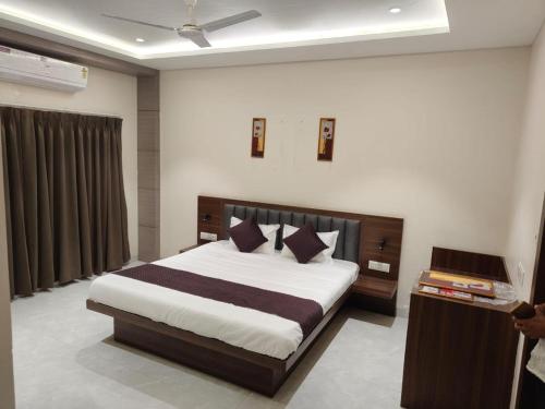 a bedroom with a large bed in a room at Hotel Bhasmaarti Ujjain in Ujjain