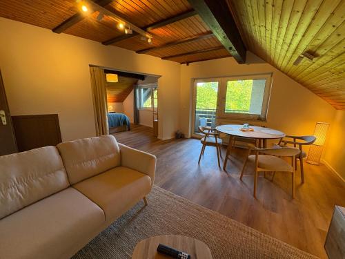 a living room with a couch and a table at Ferienwohnung Bergblick Bad Staffelstein in Bad Staffelstein