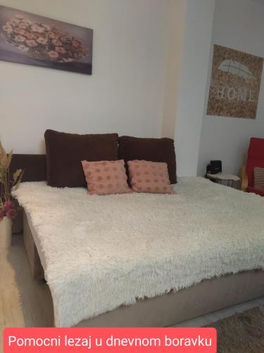 a bed with two pillows on it in a room at Apartman Nevena in Subotica