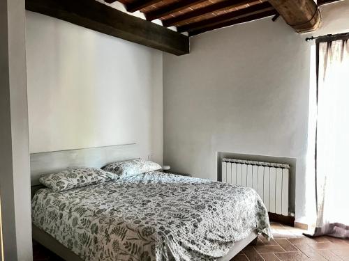 a bedroom with a bed with a comforter at Angolo,di Chianti in Castelnuovo Berardenga