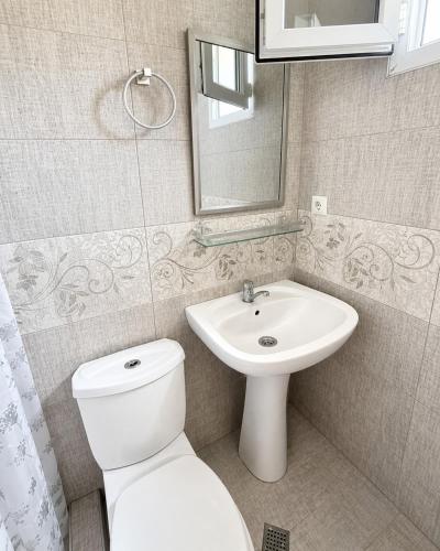 a bathroom with a white toilet and a sink at Hotel Arev Kobuleti in Kobuleti