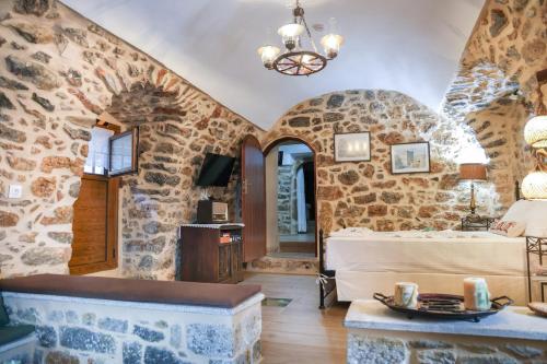 a living room with a stone wall at Stratis Tower Since 1892 in Oitylo