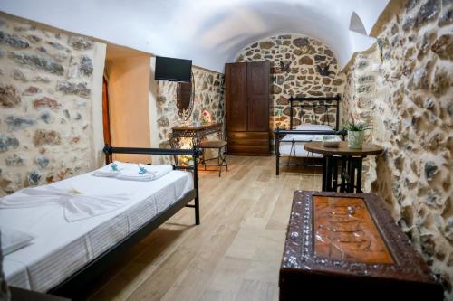 a bedroom with a bed and a table in a room at Stratis Tower Since 1892 in Oitylo