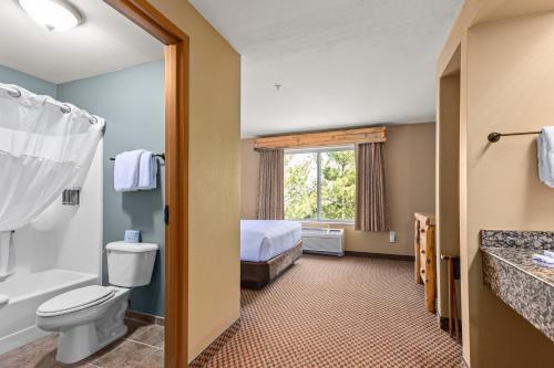 a bathroom with a toilet and a bed in a room at The Lodge at Brainerd Lakes, Trademark Collection by Wyndham in Baxter