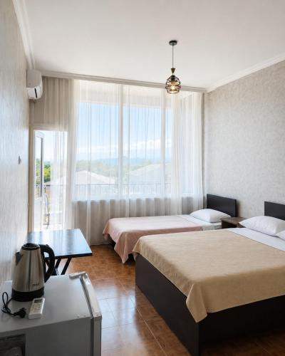 a hotel room with two beds and a window at Hotel Arev Kobuleti in Kobuleti