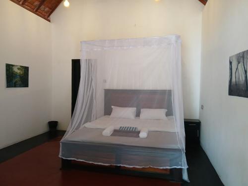 a bed with a canopy in a room at Kite Brothers Resort in Kalpitiya