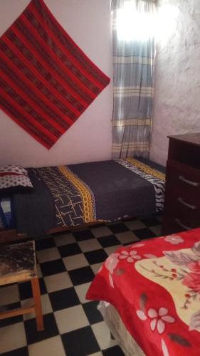 a bedroom with two beds and a window with a curtain at maimareña in Maimará