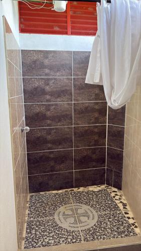 a bathroom with a shower with a tiled floor at Santa Ana Campestre in Tinjacá