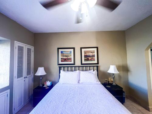 a bedroom with a bed with two lamps and two pictures at Sandy Beach Princesa B309 Ocean Front Resort in Puerto Peñasco