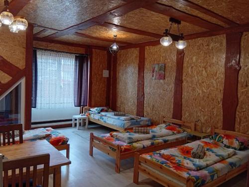 a living room with three beds and a table at Atpūtas vieta- Mini ZOO BUKI in Vārve