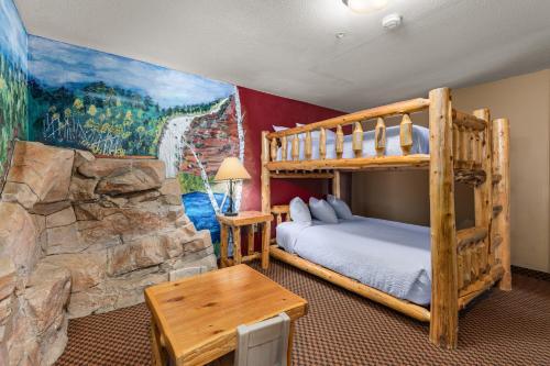 a bedroom with a bunk bed and a rock wall at The Lodge at Brainerd Lakes, Trademark Collection by Wyndham in Baxter