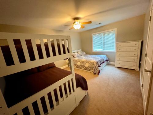 a bedroom with two bunk beds and a ceiling fan at Lake Life Adventures 4 Bedroom Home in Lake Harmony