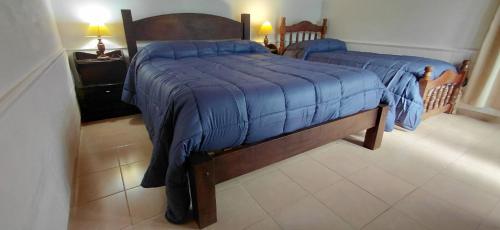 a bedroom with two twin beds with blue blankets at La Vilma Hospedaje Familiar in Paganini