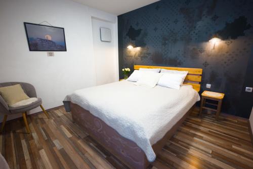 a bedroom with a bed and a chair at FRIZ&FANY Charm House in Postojna