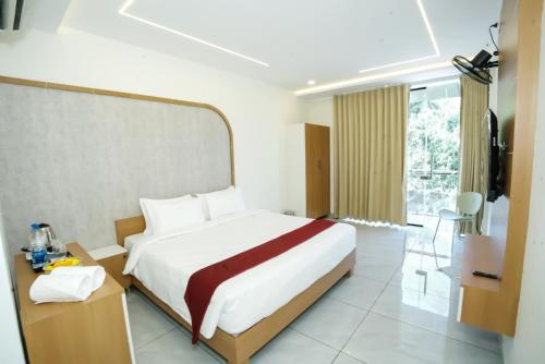 a hotel room with a large bed and a television at UK Plaza in Edappāl