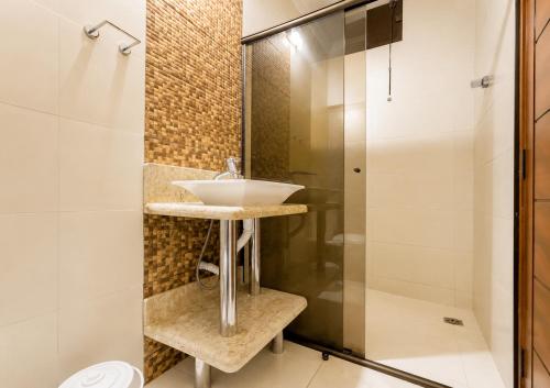 a bathroom with a sink and a shower at Pousada Miriam in Limeira