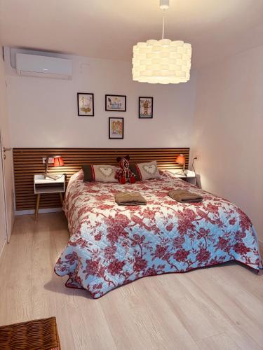 a bedroom with a large bed with a floral bedspread at Coeur d'Alsace 3 in Kaysersberg