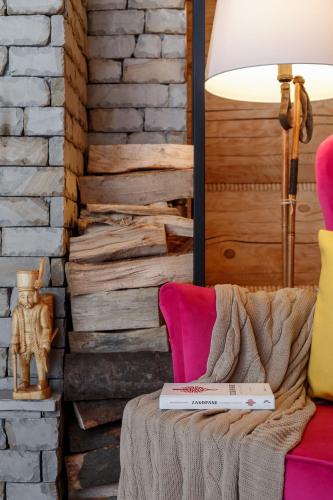 a living room with a table with a lamp and a couch at Tatra Wood House in Zakopane
