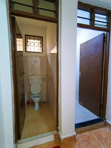 a bathroom with a toilet in a room at Bella Accomodations, Mombasa in Bamburi