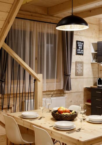 a wooden table with chairs and a bowl of fruit on it at Tatra Wood House in Zakopane