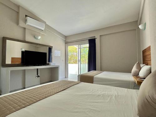 a hotel room with two beds and a tv at Hotel Mare in Santa Maria Huatulco