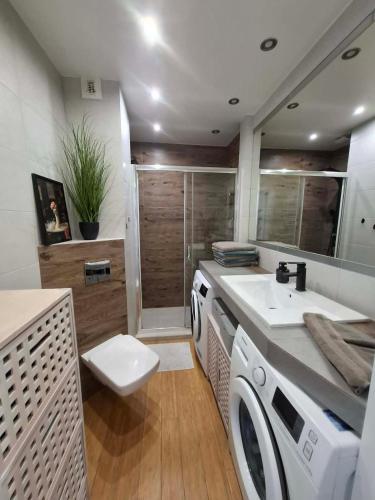 a bathroom with a washing machine and a sink at Apartament Rekiny na Wakacjach - Aquapark Reda 200m - Prywatny Parking in Reda