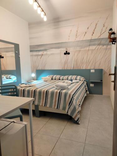 a bedroom with a bed with a striped comforter at B&B Gattopardo in Cariati
