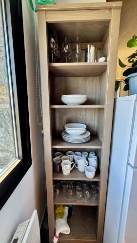 a cupboard with plates and dishes on it next to a refrigerator at Exception Ski Émerveillement in Pas de la Casa