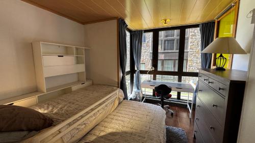 a bedroom with a bed and a desk and a window at Exception Ski Émerveillement in Pas de la Casa