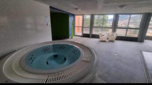 a bathroom with a large tub in the middle of a room at Cocon cosy et spa au Château des Magnans Jausiers in Jausiers