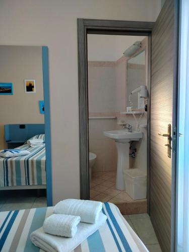 a bedroom with a bed and a bathroom with a sink at B&B Gattopardo in Cariati