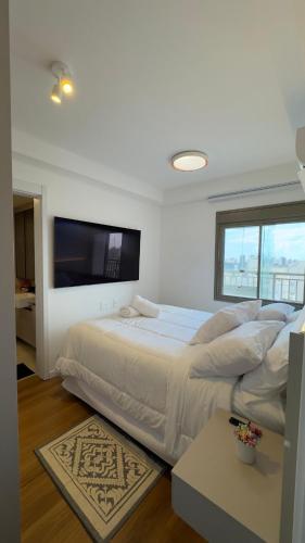 a bedroom with a large bed and a flat screen tv at Premium Suite - Perdizes - Luxury & Panoramic View in São Paulo