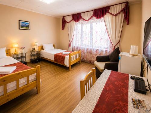 a hotel room with two beds and a living room at LG53 Tour & Hostel in Ulaanbaatar