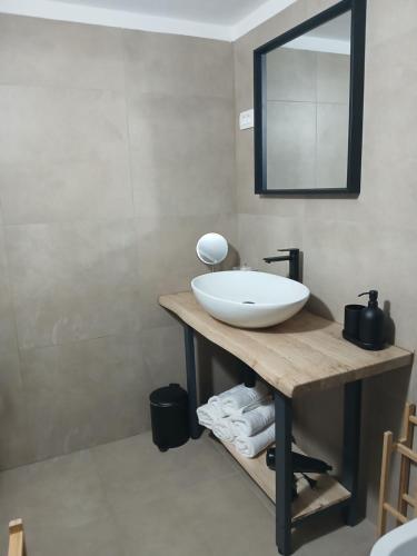 a bathroom with a white sink and a mirror at Apartmaji pri Pinku in Breginj