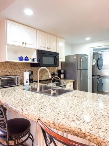 a kitchen with a sink and a refrigerator at Sandy Beach Princesa D101 Ocean Front Resort in Puerto Peñasco