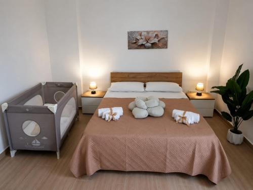 a bedroom with a bed with two stuffed animals on it at Blossom House in Isola delle Femmine