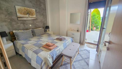 a bedroom with a bed and a chair and a window at Angelo’s Elegant Summer House in Possidi