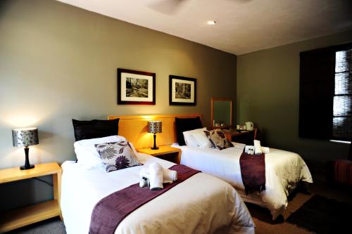 a bedroom with two beds with a teddy bear on them at Villa Paradiso in Hartbeespoort