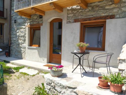 a patio with a table and chairs in front of a house at La cò viéyi - La casa vecchia in Ala di Stura