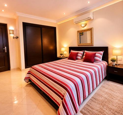 a large bedroom with a large bed with red pillows at Meknes Hamria centre ville only families and forneigners in Meknès