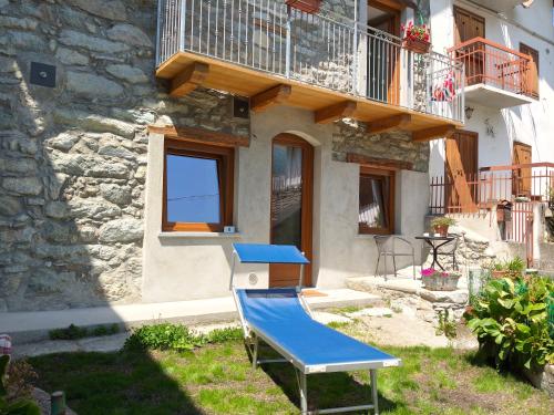 a blue chair in front of a building at La cò viéyi - La casa vecchia in Ala di Stura