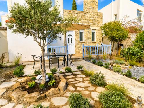 a garden with a table and a tree in front of a house at Myrtos Olive Seaside Villa in Myrtos