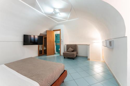a bedroom with a bed and a chair in a room at Chill House mare bus e servizi a piedi in Procida