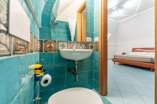 a bathroom with a sink and a toilet and a bed at Chill House mare bus e servizi a piedi in Procida
