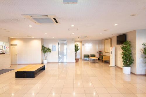 an empty lobby with plants in a building at Yono Daiichi Hotel in Saitama