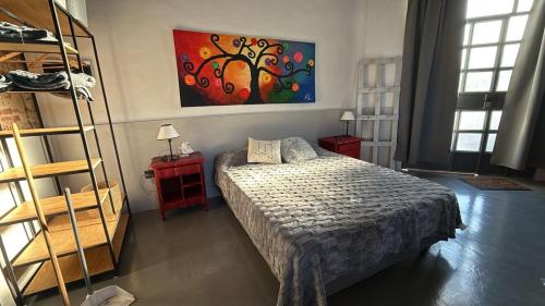 a bedroom with a bed and a painting on the wall at Apartamento El Rancho in San Pedro