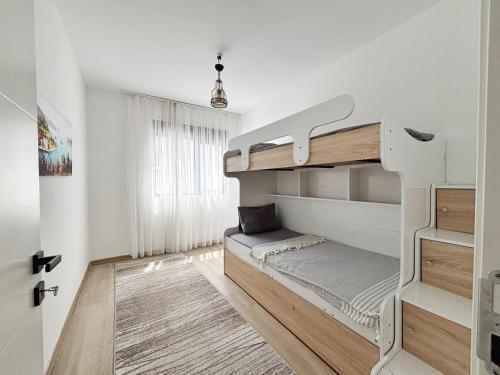 a white room with a bunk bed in it at Modern Garden House in Tivat