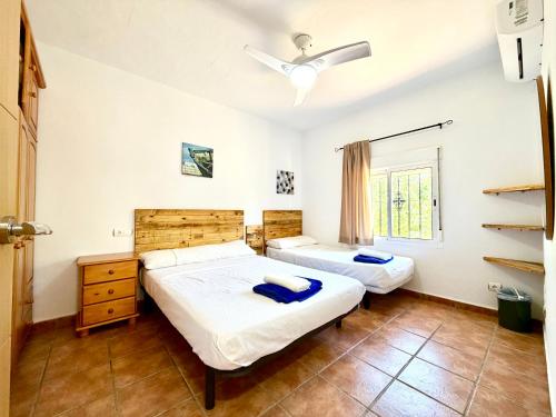 a bedroom with two beds and a window at El Naranjo del Abuelo in Málaga