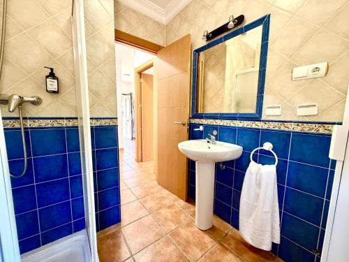 a blue bathroom with a sink and a mirror at El Naranjo del Abuelo in Málaga
